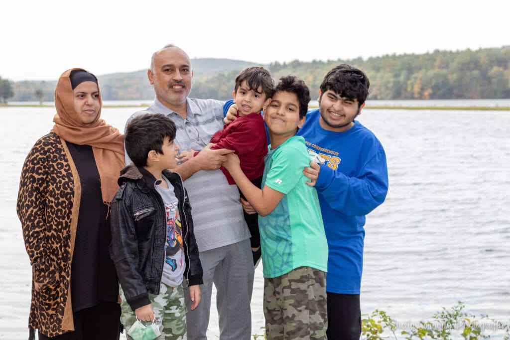 family posing near quiet river during autumn